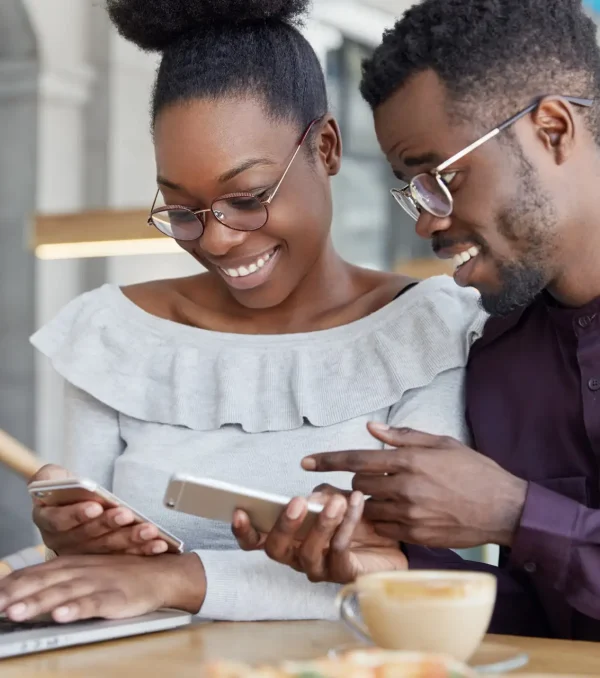 black-woman-man-have-informal-meeting-glad-view-photos-smart-phone-wear-spectacles-work-together-common-project-via-laptop-computer